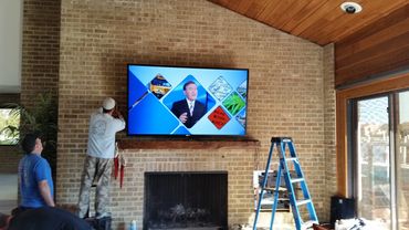 90 inch TV Installed on Brick wall over fireplace. professional tv mounting service