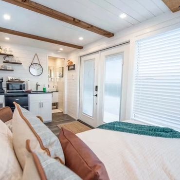 Bright, cozy studio apartment with kitchen and bed.