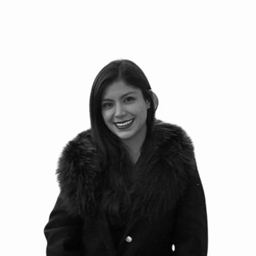 Smiling woman wearing a dark coat with a fur collar.