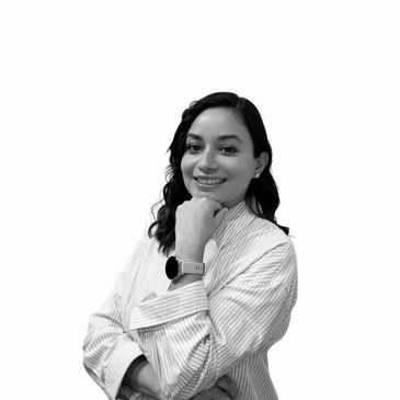 Smiling woman with striped shirt posing confidently with hand on chin.