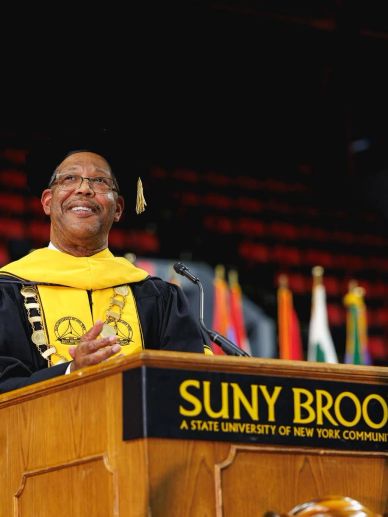 Man speaking at SUNY Binghamton graduation event.
