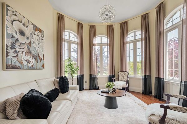 Elegant living room with cream sofa, floral curtains, and modern chandelier.