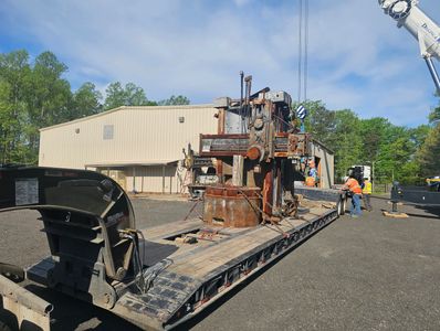 Old industrial machinery loaded on a flatbed trailer.