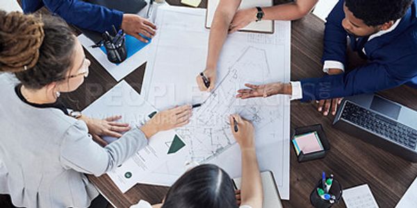 Team collaborating on architectural plans at a table.