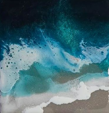 Close up of ocean coasters with blue pigments and white foaming waves