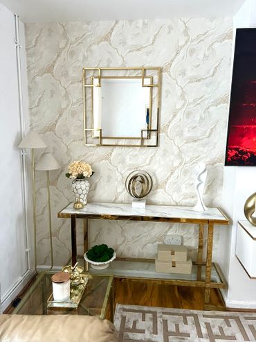 Elegant living room corner with gold accents and marble textures.