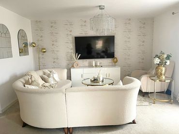 Elegant neutral-toned living room with curved sofa and gold accents.