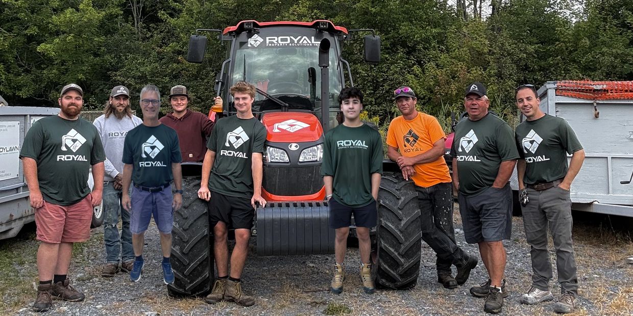 Group of workers posing in front of a tractor.