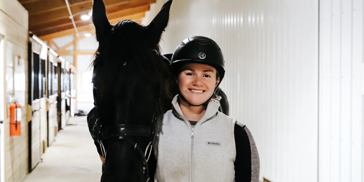 Callie, trainer at Legacy Sport Horses standing with a Friesian Cross mare in Michigan City, IN