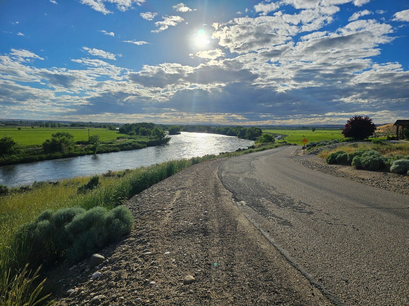 Black pencils in a gray holder next to a stack of white magazines with a camera in the background.