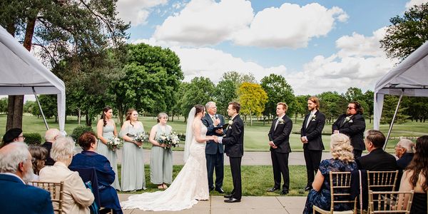 Outdoor wedding ceremony with bride and groom exchanging vows.