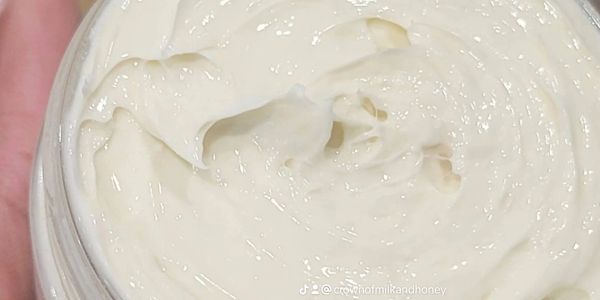 Close-up of creamy white lotion in a container.