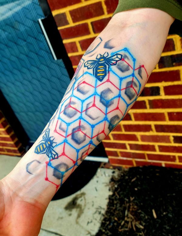 Geometric tattoo bee , hexagon honeycomb spiral on hand under organic tree