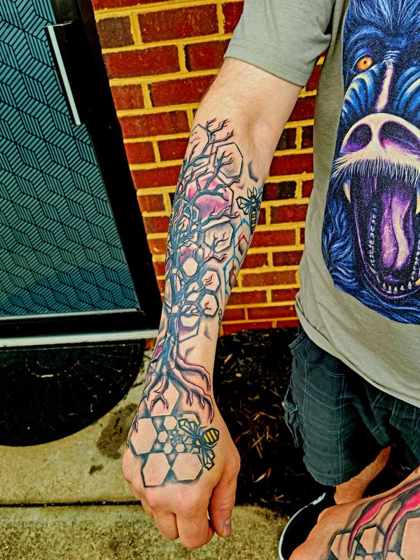 Geometric tattoo bee , hexagon honeycomb spiral on hand under organic tree