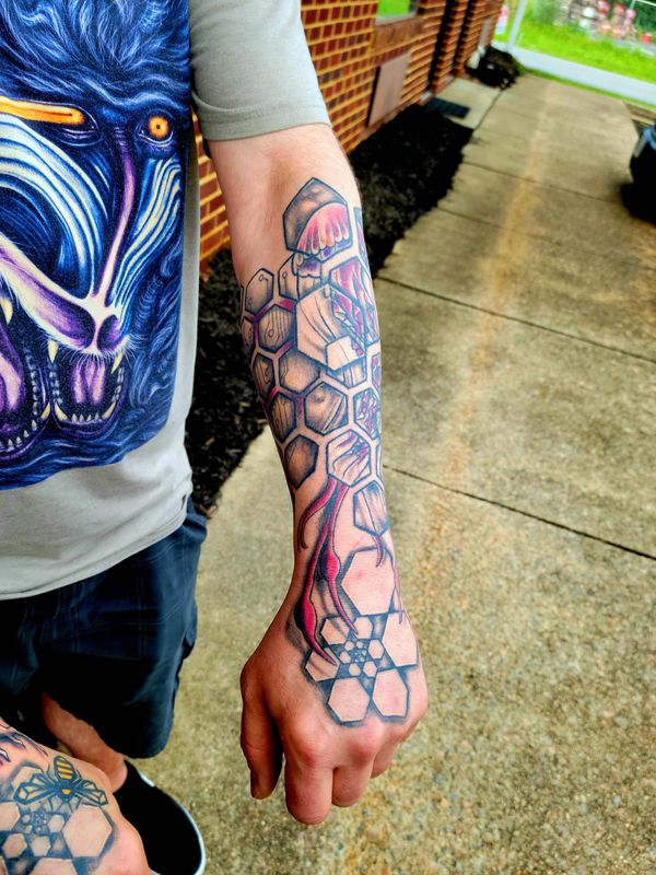Geometric tattoo bee , hexagon honeycomb spiral on hand under organic tree