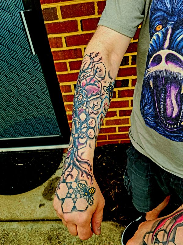 Geometric tattoo bee , hexagon honeycomb spiral on hand under organic tree