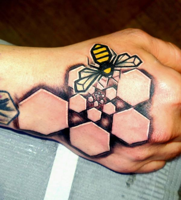 Geometric tattoo bee , hexagon honeycomb spiral on hand under organic tree