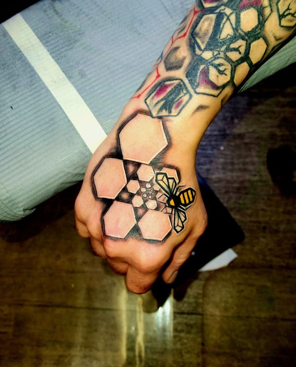 Geometric tattoo bee , hexagon honeycomb spiral on hand under organic tree