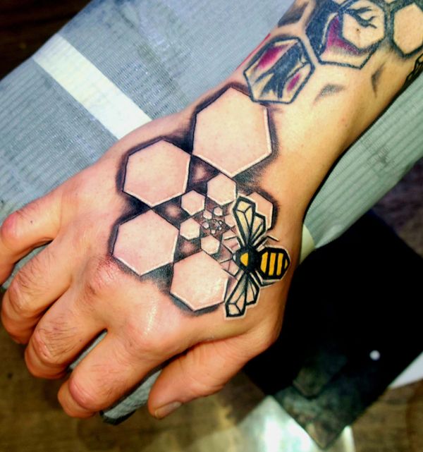 Geometric tattoo bee , hexagon honeycomb spiral on hand under organic tree