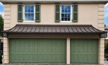 A house with green garage doors and two windows with shutters.