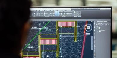 Person viewing architectural blueprint on computer screen.