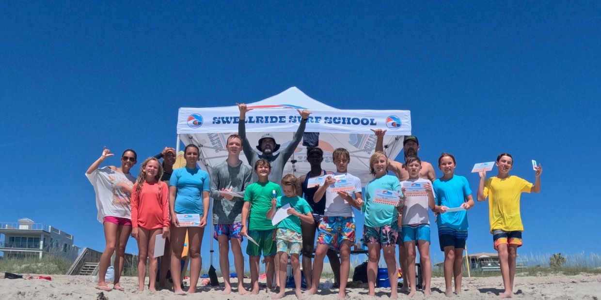 Group photo at Swellride Surf School on the beach.