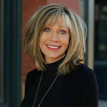 Close up image of a girl with brown hairs smiling at the camera