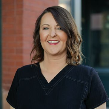 Close up shot of a lady wearing black dress smiling at the camera