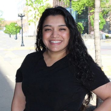 Close up image of a girl wearing black dress and Curley hairs