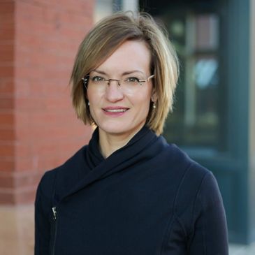 Close up shot of a lady with brown hairs smiling at the camera