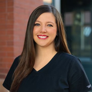 Close up image of a lady in black dress smiling at the camera