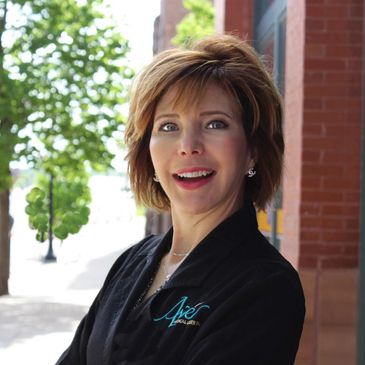 Close up image of a girl with short hairs smiling at the camera