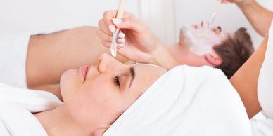 A lady along with a boy taking face massage therapy on the face