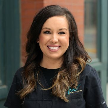 Close up shot of a girl with brown hairs smiling at the camera