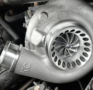 Close-up of a metallic turbocharger with visible turbine blades.