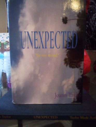 Book titled 'UNEXPECTED' by Joann Taylor with a cloudy sky cover.