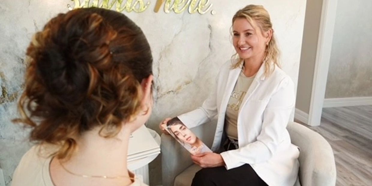 A smiling woman in a white coat consulting with a client in a cozy office.