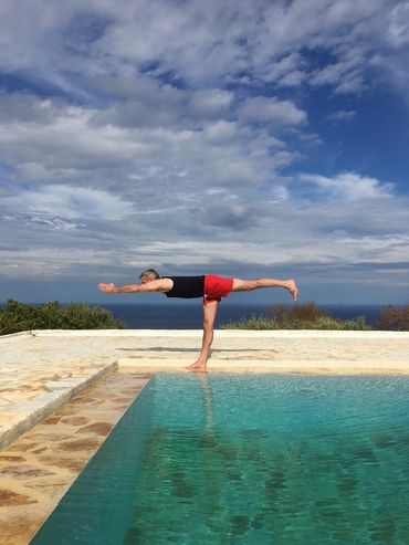 Virabhadrasana III warrior 3 by the pool in Greece