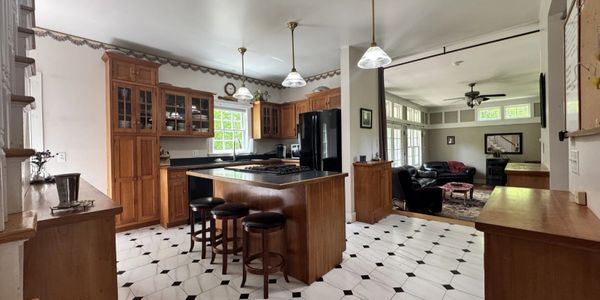 Spacious kitchen with wooden cabinets and island seating.