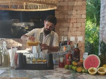 Bartender pouring juice into glasses.