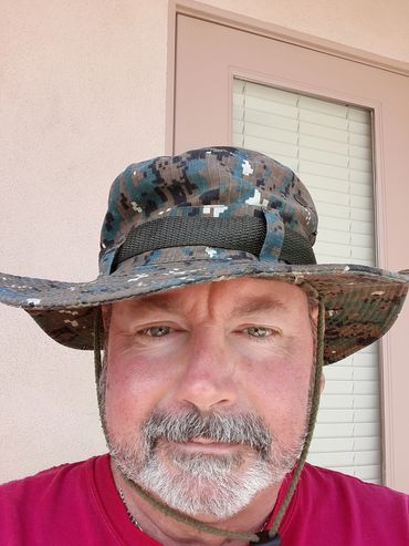 Middle-aged man wearing a camouflage hat and red shirt.