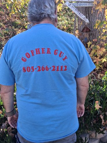 Man wearing a blue T-shirt with "GOPHER GUY" and a phone number printed on the back.