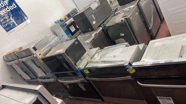 A row of stainless steel kitchen appliances in a store.
