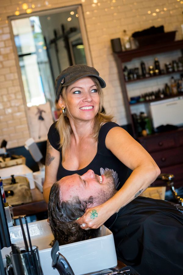 Hairdresser washing a clients hair photographed by Reichert Photography