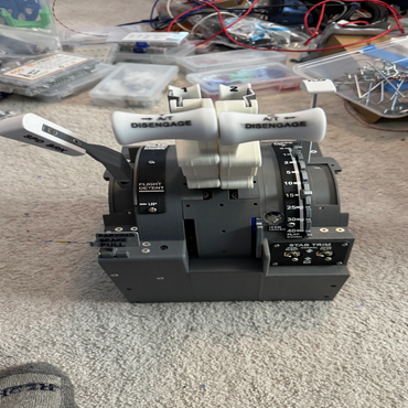 Close-up of an aircraft throttle quadrant simulator on a carpeted floor.