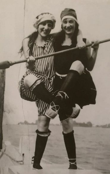 Two girls in early twentieth century swimsuits smiling