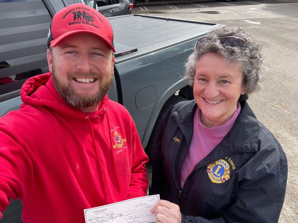 a volunteer presents a funding check