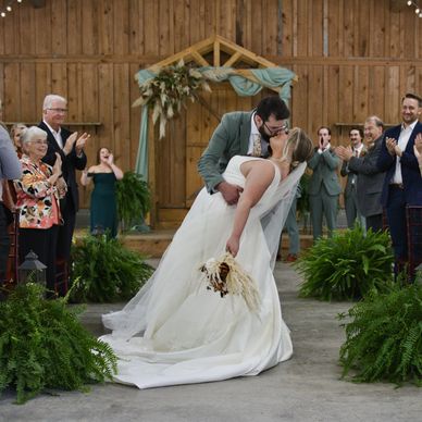 Exit photo of couple kissing after their wedding ceremony at the Camp at Buffalo Mountain.