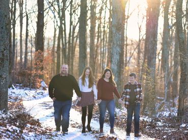 A family of 4 walking in the woods at Colley Hill Farms in Dandridge, TN.