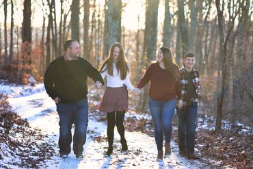A family of 4 skipping in the woods at Colley Hill Farms in Dandridge, TN.